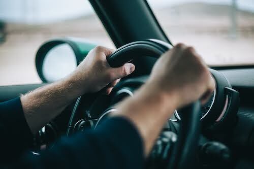 man with both hands on the steering wheel